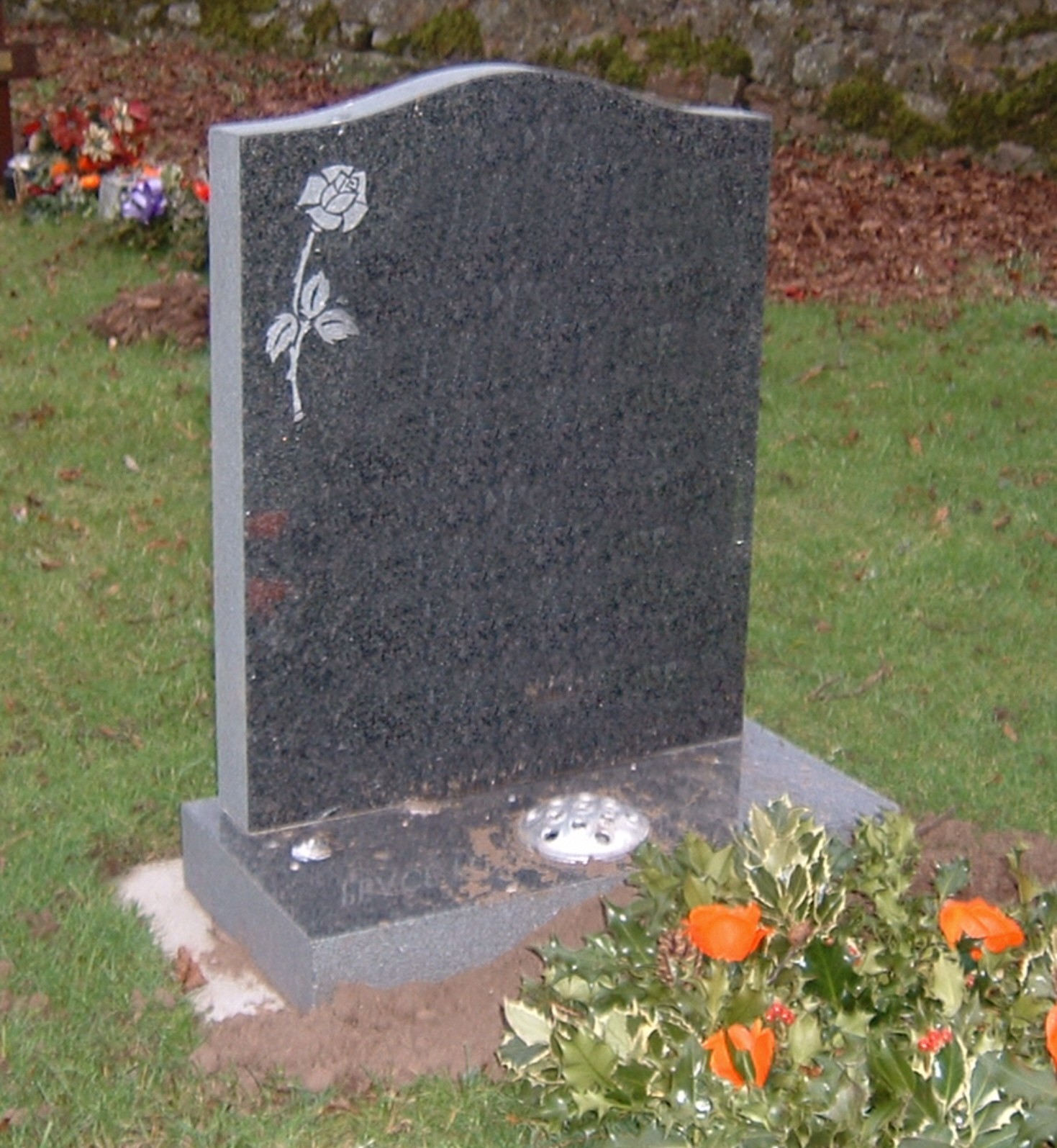 PJ15 - The simple rose design compliments the o-gee shape to this dark grey granite memorial. Lawn Memorial, Headstone